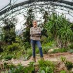 Gardener standing holding trowel in Eden Project Mediterranean Biome